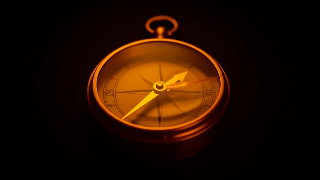 An amber compass with a blank dial, the needle spinning freely with a motion trail, no cardinal directions visible, dark background with warm amber glow